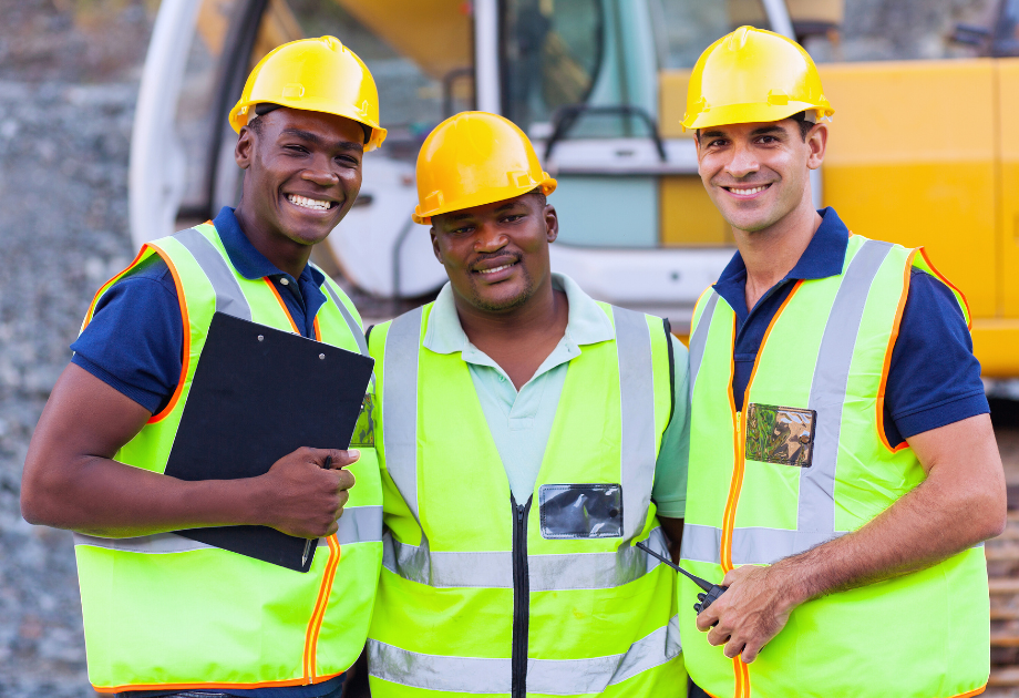 3 construction workers smiling at a camera